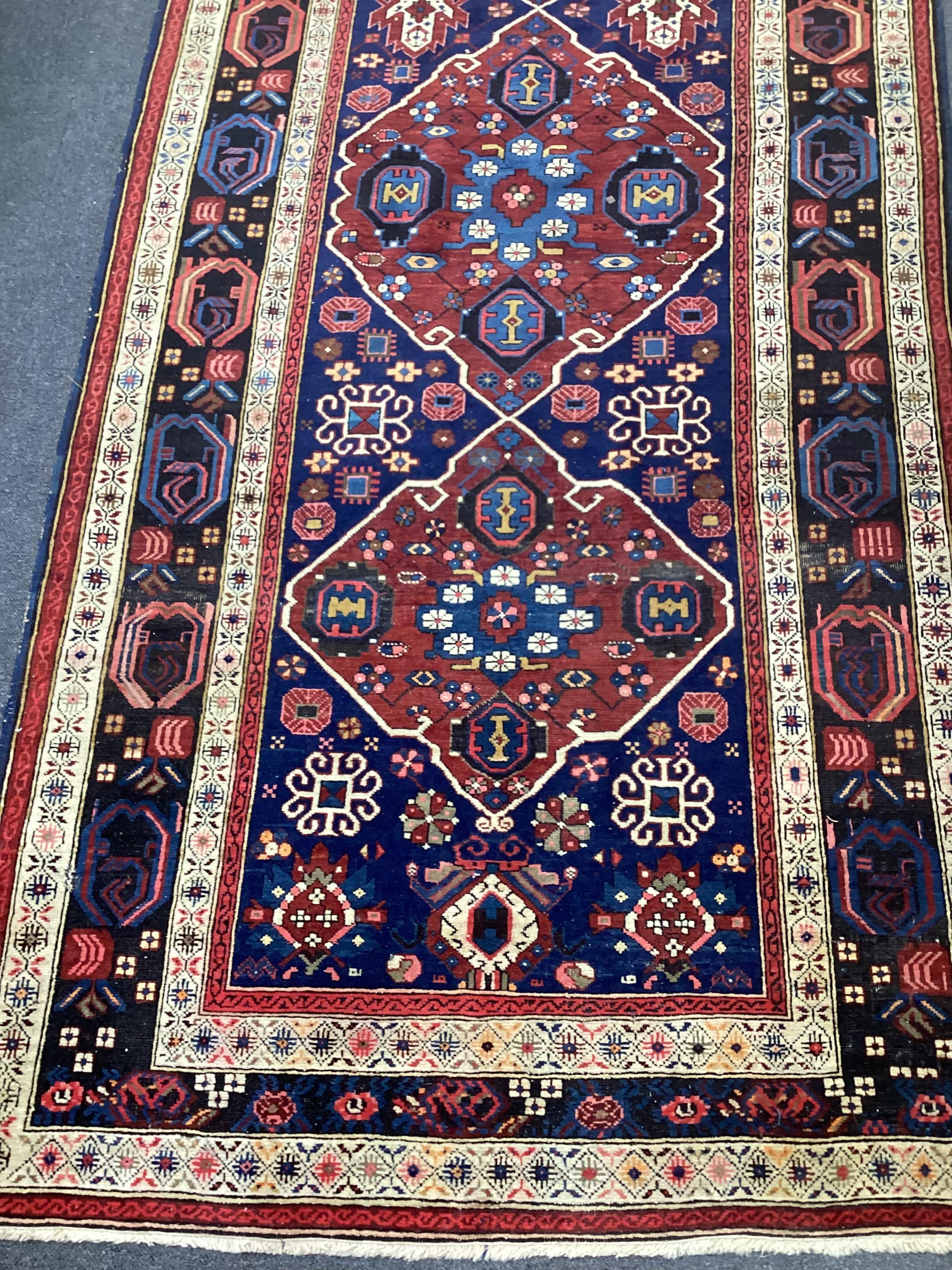 A South Caucasian blue ground runner, the field woven with five red lozenge panels, 390 x 118cm